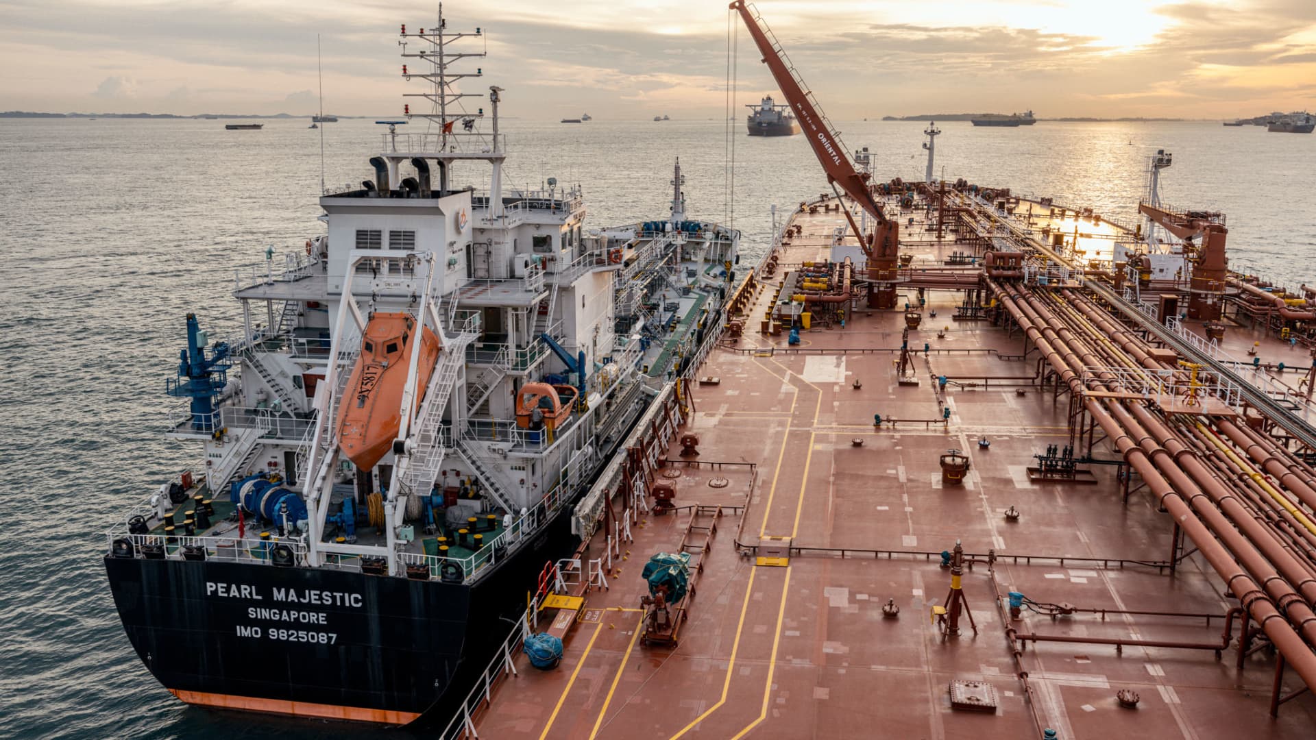 An oil tanker being serviced by a bunkering vessel.
